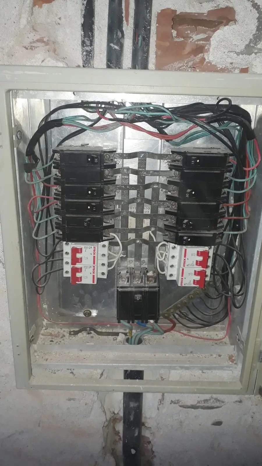 Quadro elétrico antigo com componentes de diferentes padrões